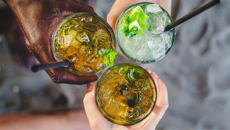 Three people holding their cocktails together