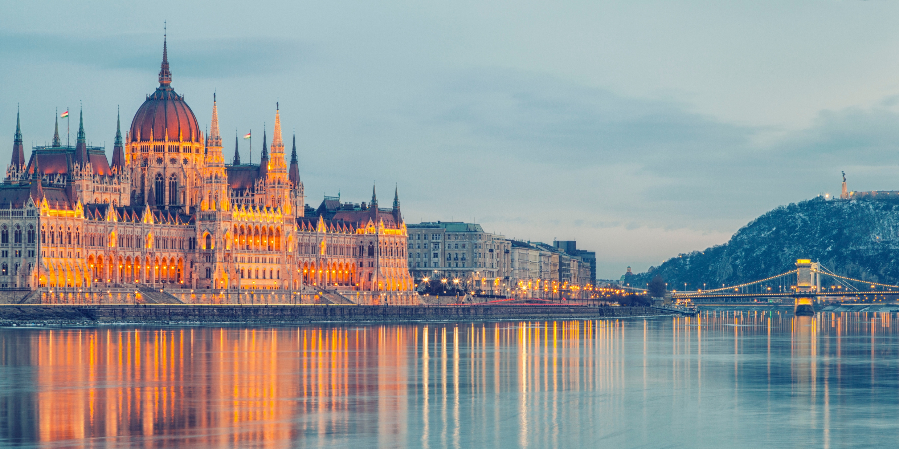 The Hungary Parliament Building in Budapest lit up at night on the edge of the river