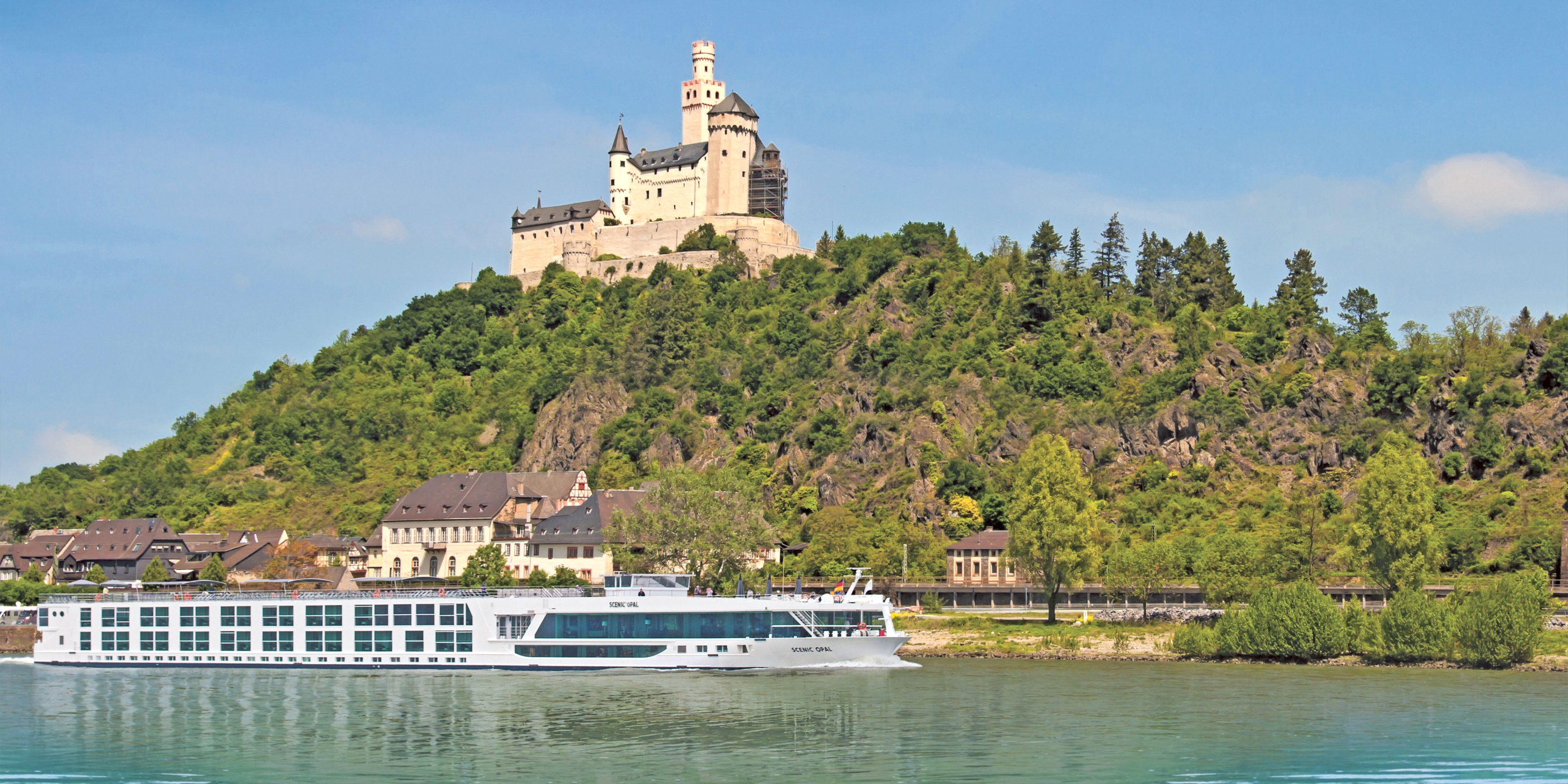 Luxury river cruise ship sailing past the Marksburg castle on a hill