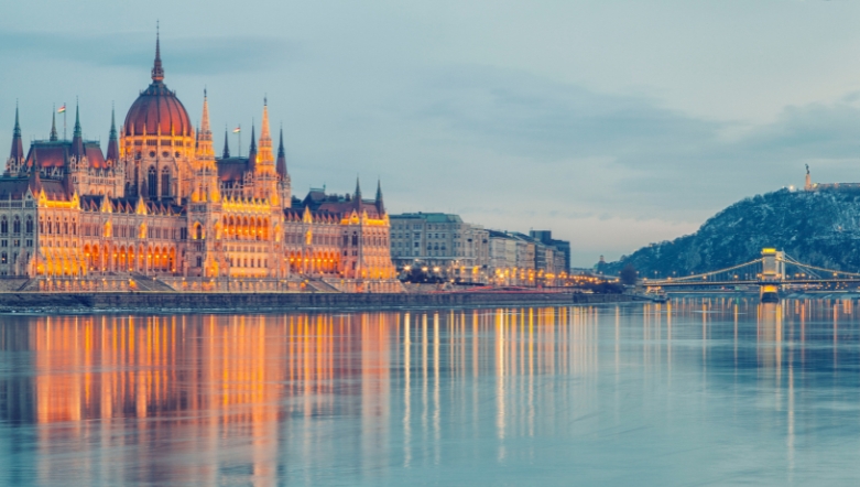 The Hungary Parliament Building in Budapest lit up at night on the edge of the river