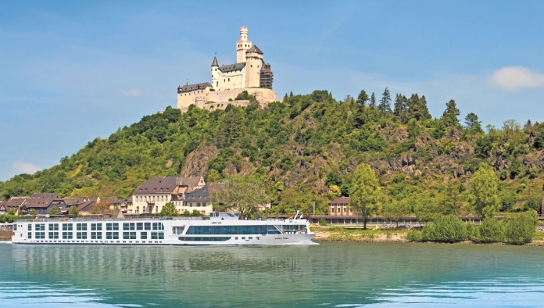 Luxury river cruise ship sailing past the Marksburg castle on a hill